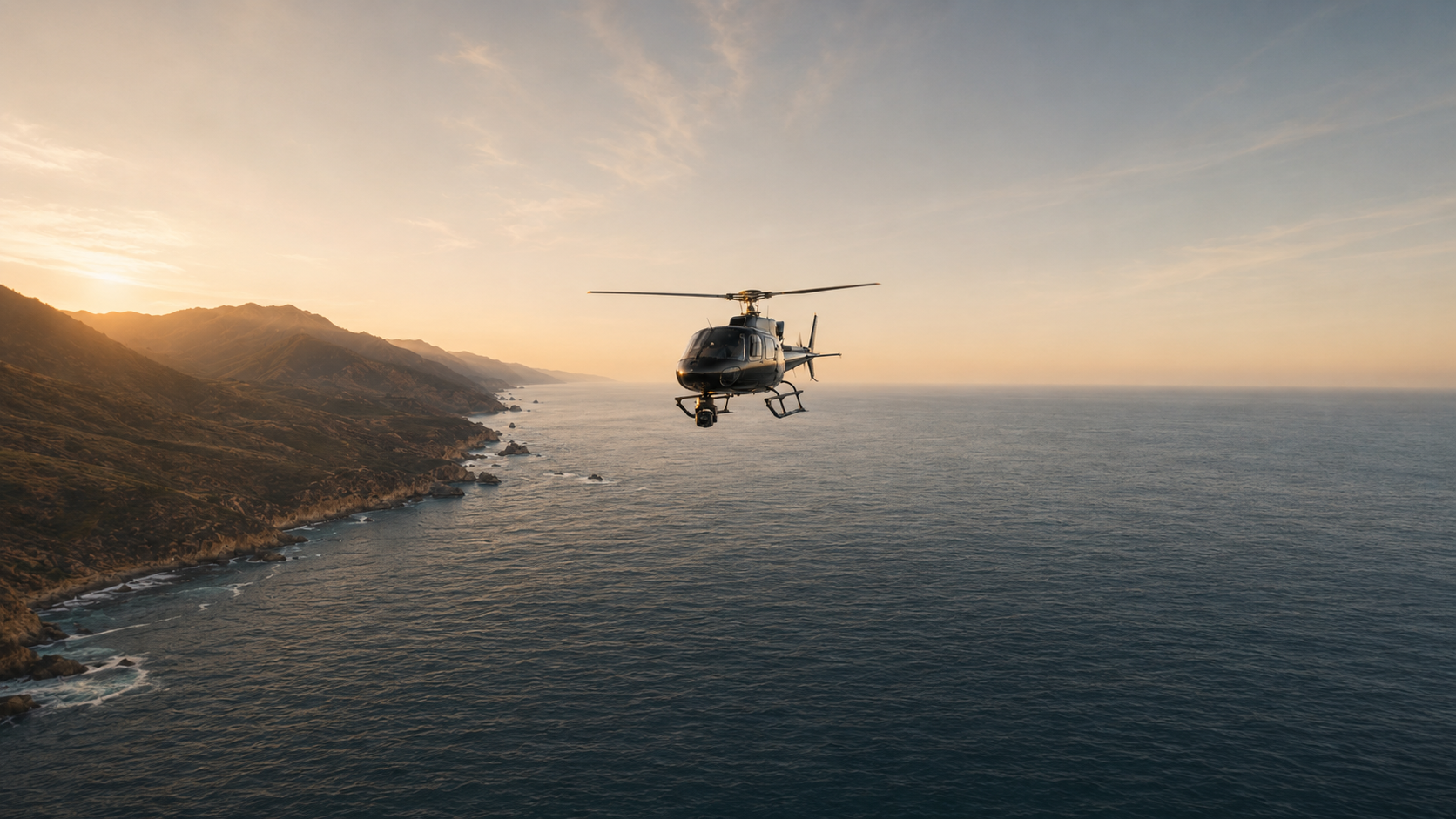 Camera-equipped helicopter flying above a coastline at golden hour